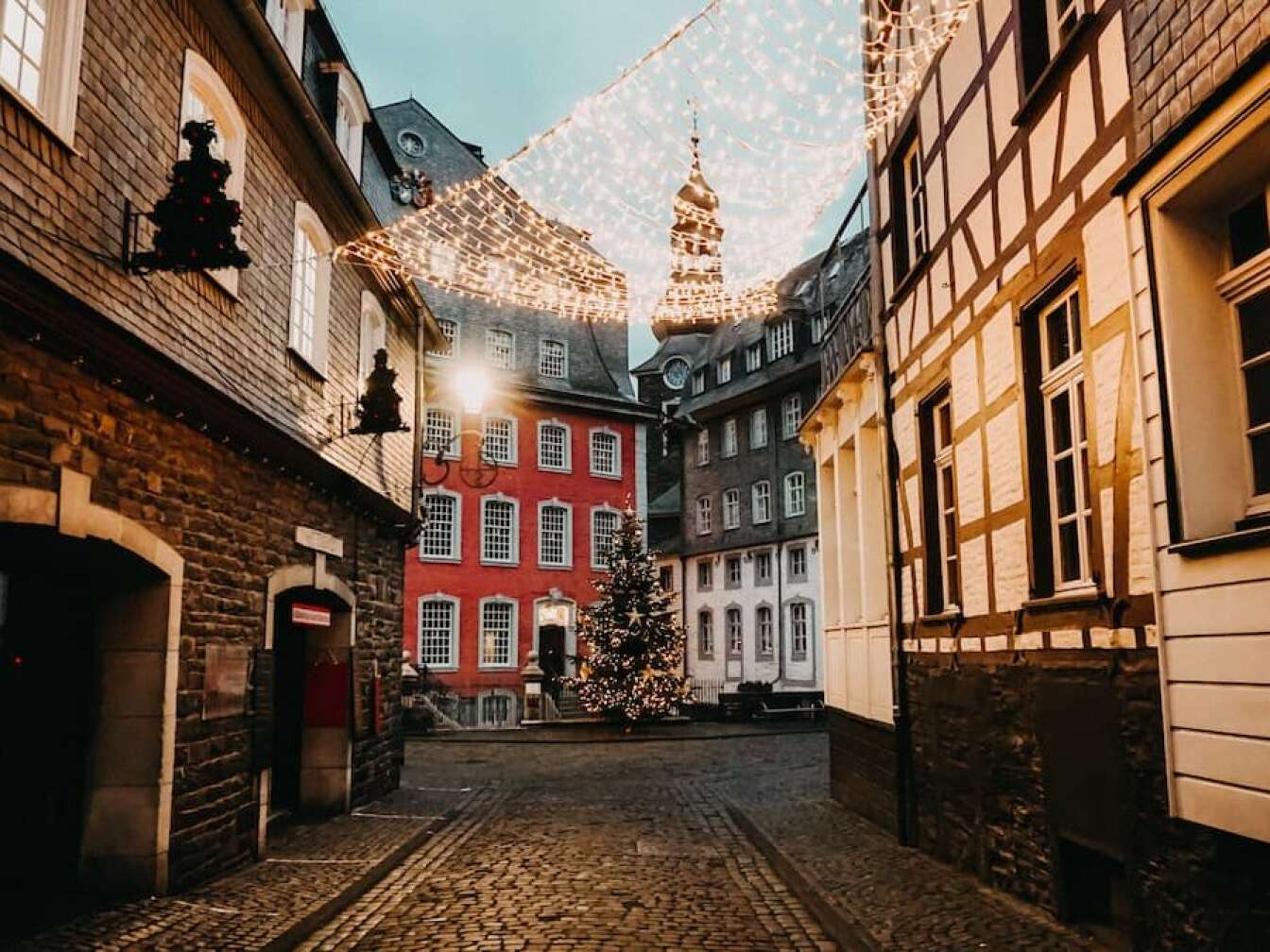 Eine beleuchtete Gasse führt zum Weihnachtsbaum in Monschau